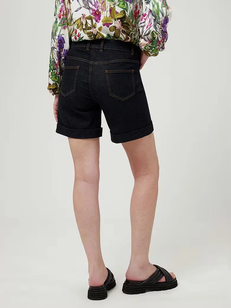 Marcel Ostertag Damen-Bermudashorts aus Jeans in Dunkelblau und 5-Pocket Style, Kontrastnähte in Orange und umgeschlagener Saum, getragen an einem weiblichen Model, Schuhe und Bluse sind nicht relevant, Rückansicht.