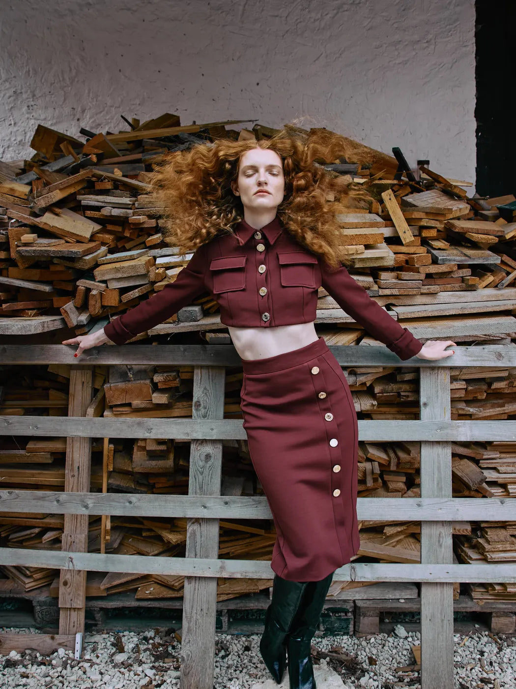 Model trägt Damen-Kurzjacke in Rostbraun, Hemdkragen mit Knopfleiste und Logo-Knöpfe in Gold, aufgesetzte Brusttaschen. Dazu passender Rock, Vorderansicht.